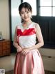 A woman in a red and white dress posing for a picture.