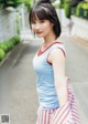 A woman in a blue tank top and red and white striped skirt.