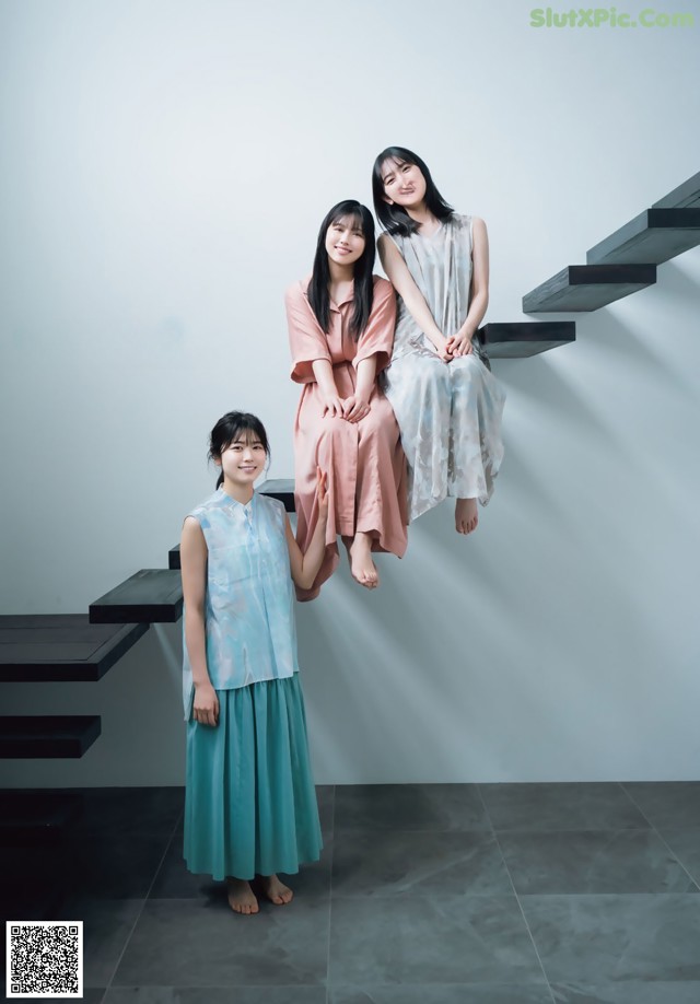 A group of three women sitting on top of a set of stairs.