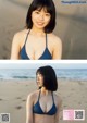 A woman in a blue bikini standing on a beach.