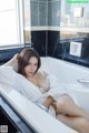 A woman in a bathtub with a white robe on.