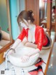 A woman in a red leather outfit is washing her hands in a sink.